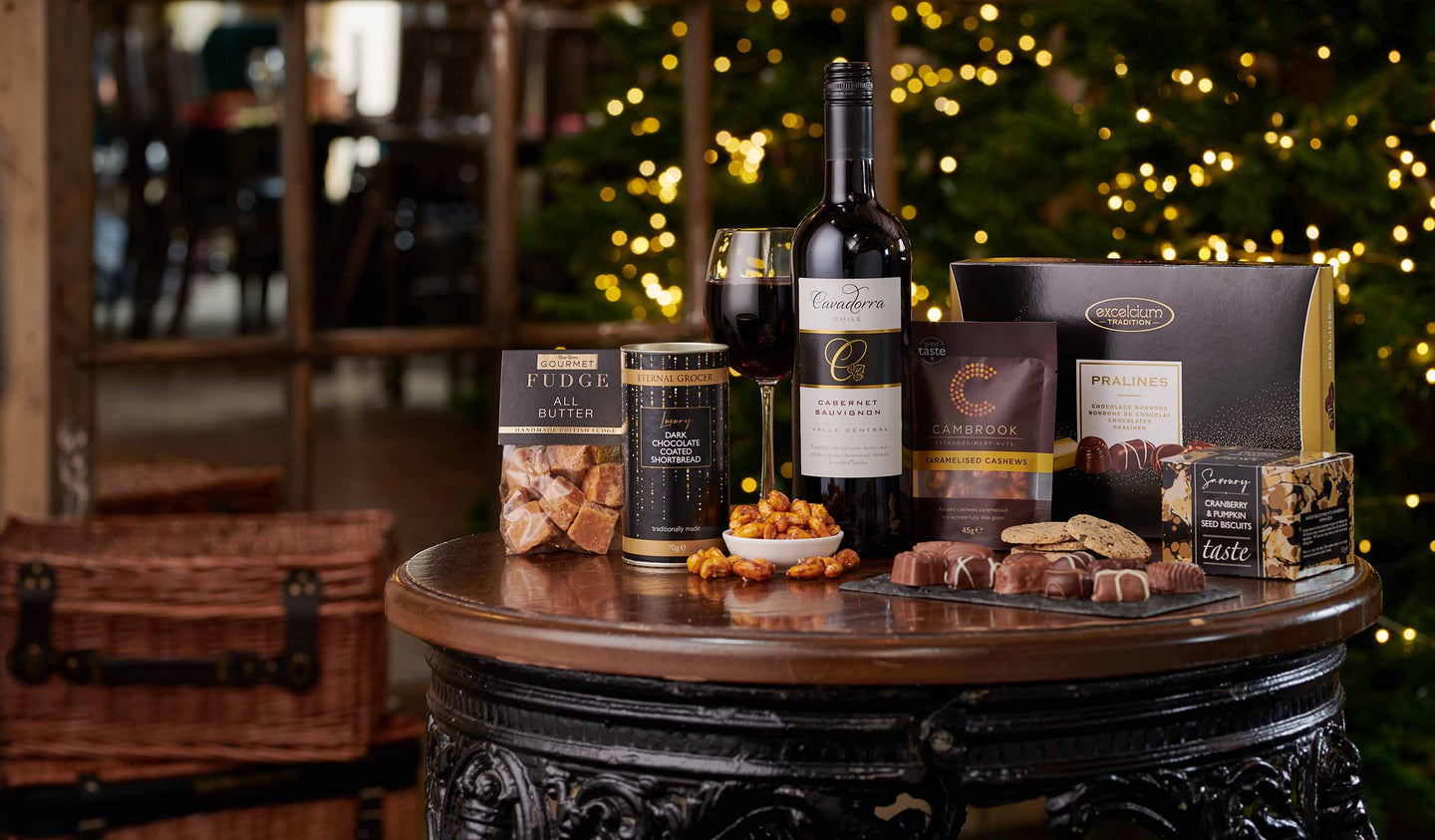 Red Wine gift hamper laid on a table in front of a Christmas tree